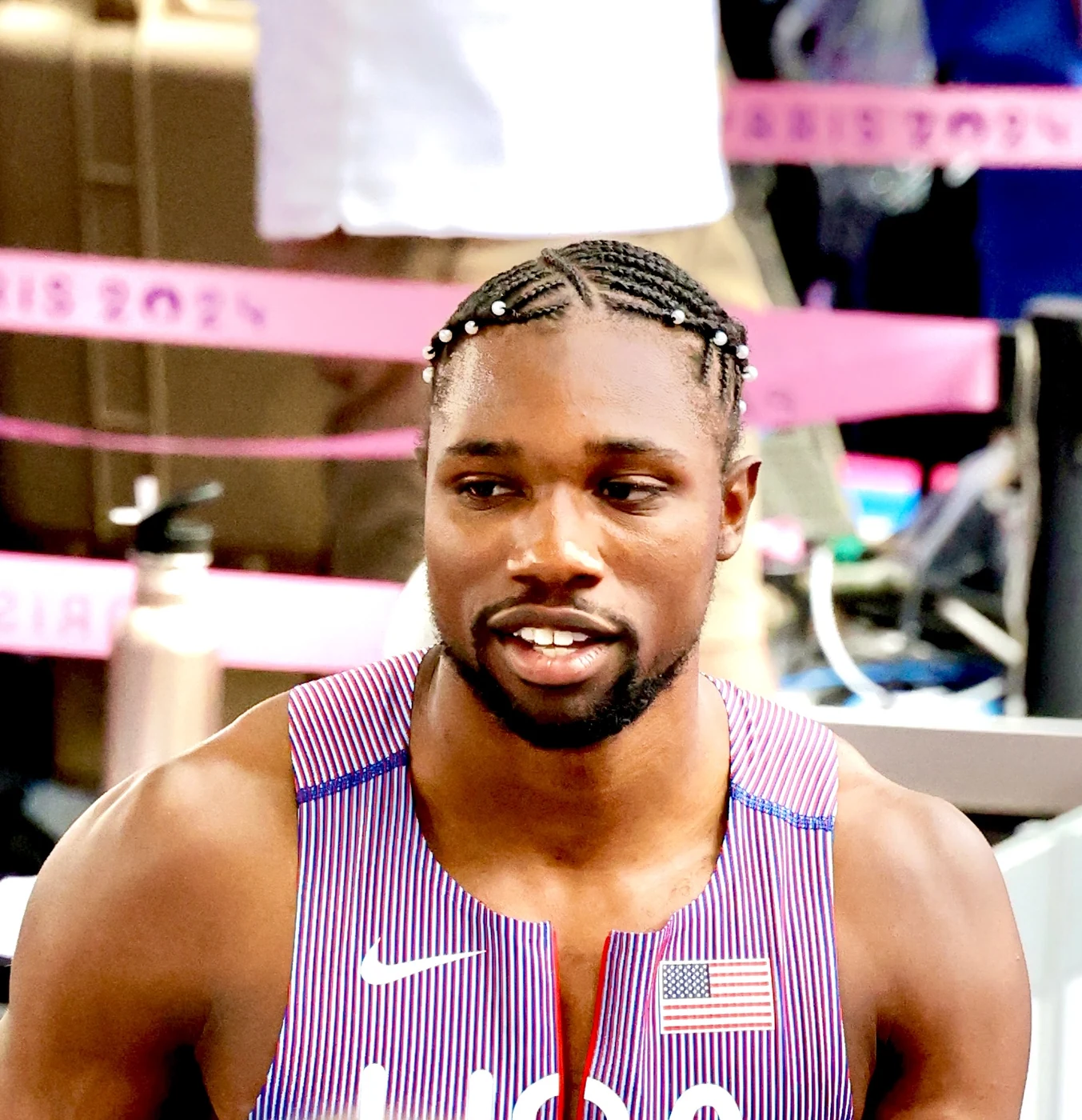 A Team USA sprinter in a striped singlet at the Paris 2024 Olympic Games